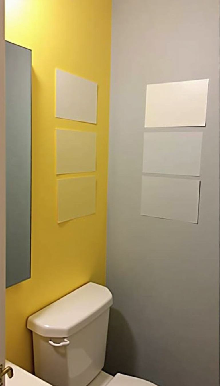 A photo of a bathroom with grey and yellow paint samples.