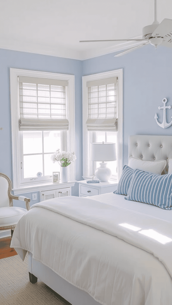 A bright, airy bedroom featuring soft blue walls, white bedding, and nautical decor elements.